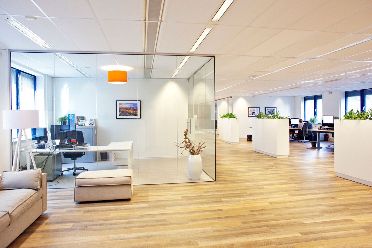 Moderne kantoorinrichting in Zeist, Utrecht met kantoortuin, glazen scheidingswanden en houten vloer.
